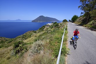 Cyclist at Punta del Legno Nero at Quattropani overlooking the island of Salina