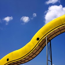 Yellow slide in front of blue sky