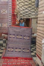 Carpet dealer shows a Moroccan carpet