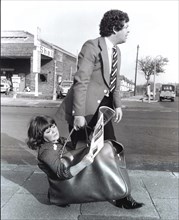 Man carries woman in bag