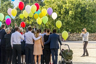 Photographer takes photos of a festive gathering with colourful balloons