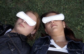 Two women with slips over the eyes