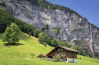 View of a farm house near Lauterbrunnen and with Staubbach Falls in the background