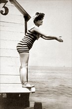 Woman in striped swimsuit wants to jump into the water