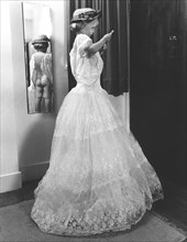 Child in white dress in front of a mirror