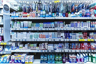 Toothpaste and toothbrushes in a supermarket shelf