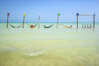 Tourists in hammocks on a beach