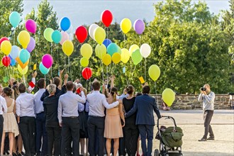 Photographer takes photos of a festive gathering with colourful balloons