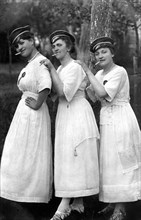 Three women with cigarette and cap