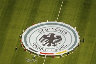 Young football players with rolled out banner with emblem German Football Association