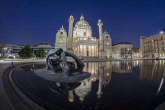 Karlskirche with sculpture and water reflection at night