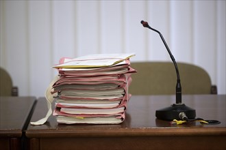 Trial files are on a judge's table in the courtroom