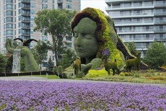 Plant sculpture Mother Earth with modern buildings behind