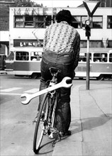 Man with huge wrench on bicycle ca. 1970s