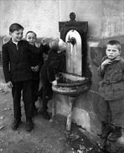 Children drink from Brunnen