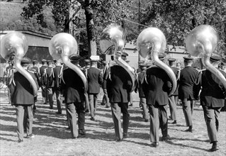 Five large wind instruments during a parade ca. 1955