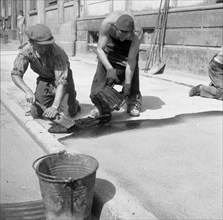 Road workers tar a road
