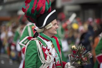 Carnival artist in green uniform with bouquet of flowers