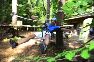 Man in the zipline from the forest adventure center and climbing forest Riegling