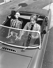 Skeleton and man driving car