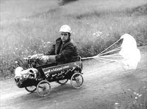 Man in soapbox with brake parachute ca. 1970s