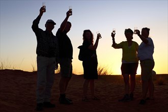 Tourists at the sundowner with glass in hand