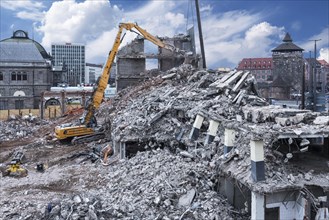 Excavator in building rubble during demolition of a building