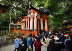 Tourists entering Senbon Torii path leading to inner shrines of Fushimi Inari Taisha head shrine in Fushimi Ward
