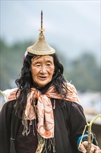 Old woman with traditional hat of the mountain people of the Laya