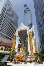 Decorated Hindu shrine with golden Brahma statue in front of luxury hotel W Bangkok
