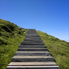 Wooden staircase in front of blue sky