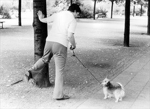 Woman showing a dog how to pee