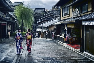 Two girls in Yukata kimonos with their obi walking down Yasaka dori street