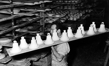 Man transports ceramic bells for firing