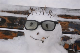 Snowman on a bench with glasses and cigarette butt