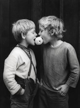 Two boys share an apple about 1970s