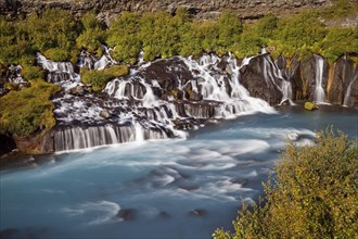 Waterfall Hraunfossar with the blue river Hvita