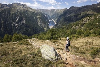 Hiker on the hiking trail from Alpe Corte del Sasso to Alpe Corte di Mezzo