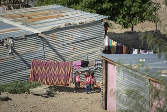 Children between corrugated-iron huts in the slum district
