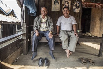 Two locals are sitting in their hut