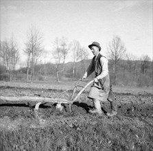 Farmer with an old wooden plough