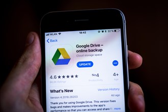 Hand holding an iPhone displaying Google Drive app