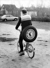 Cyclist transports car tire