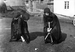 2 girls in traditional traditional costume playing with eggs ca. 1930