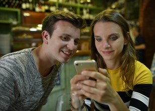 Young couple looks interested in mobile phones