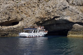 Tourist boat entering the sea cave Grotta Perciata