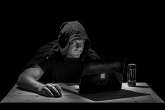 Man is sitting at the table in a dark room