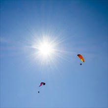 Paragliders in a blue sky