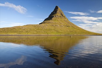 Mount Kirkjufell with water reflection in the fjord Grundarfjordur