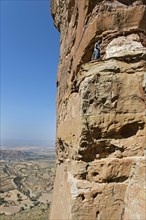 Local guide climbs to the entrance Abuna Yemata monolithic church in the Gheralta Mountains near Hawzen